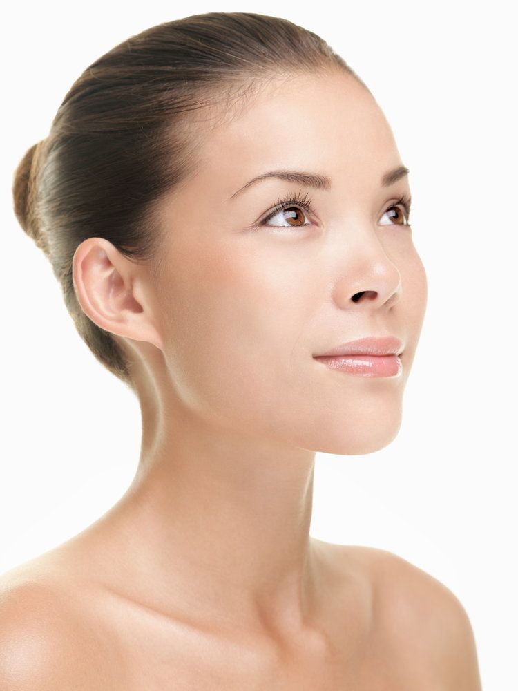 A Caucasian woman with a youthful glow and bony collarbones looks upward hopefully.