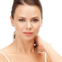 Una hermosa mujer sostiene su mano en su cuello, acentuando su hermosa piel.